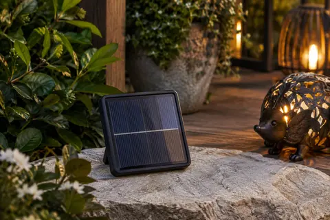 Panneau solaire de remplacement en plastique posé dans un jardin près d’une figurine décorative lumineuse