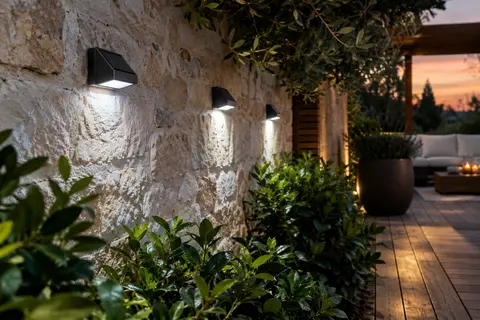 Appliques solaires murales compactes éclairant un passage près d’une terrasse au crépuscule