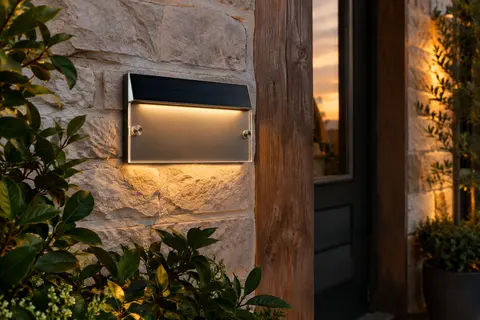 Plaque solaire personnalisable de numéro de maison fixée près d’une entrée au crépuscule